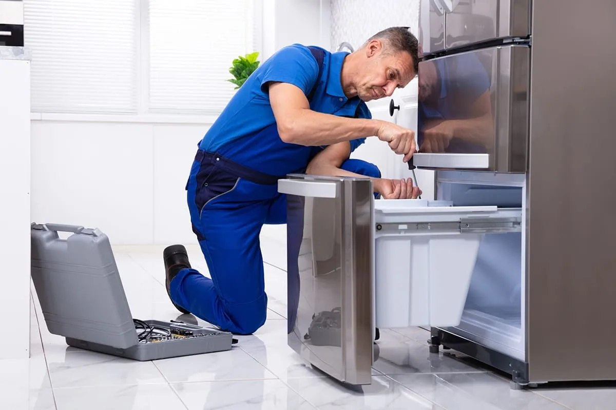 Técnico de Top Solution reparando una nevera en Tenerife