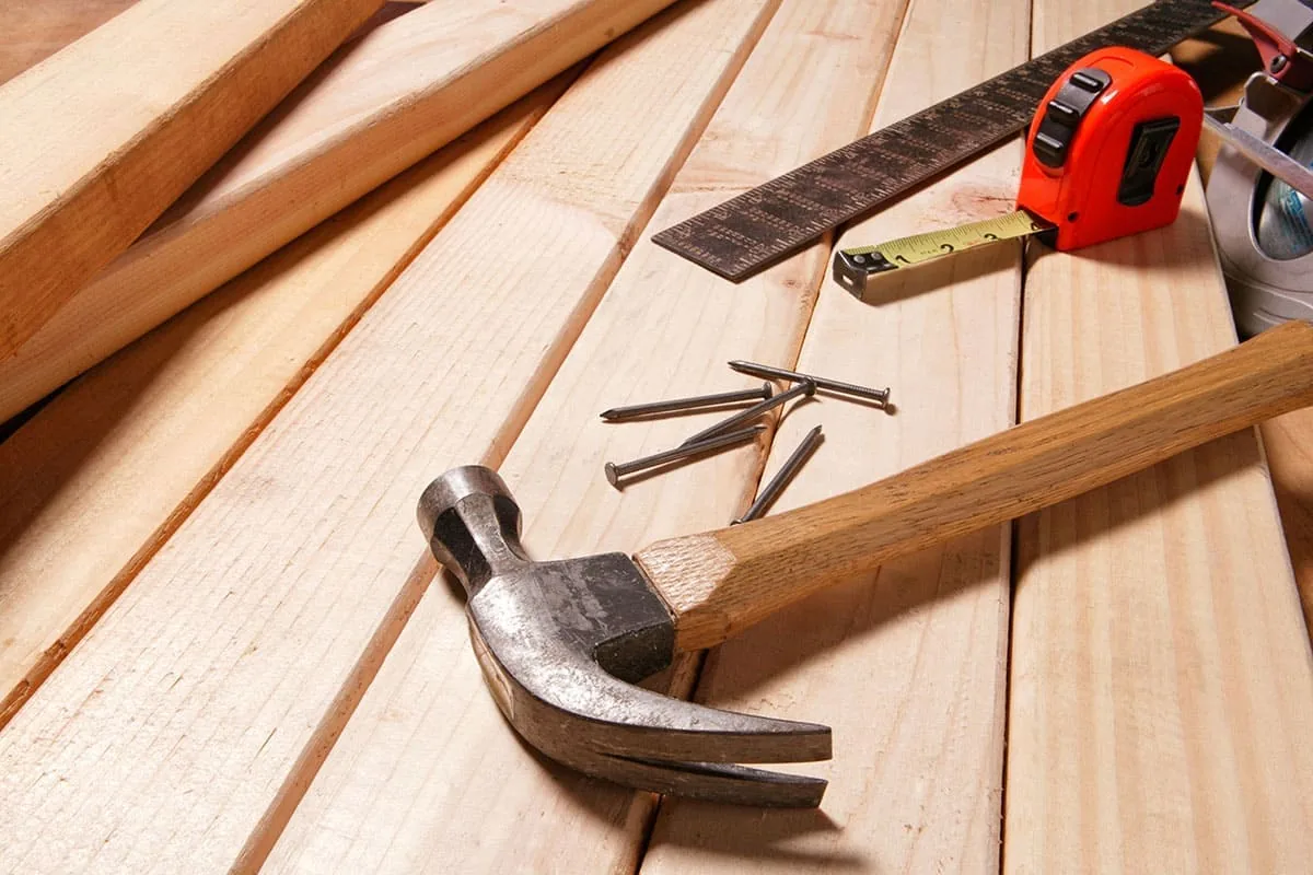 Carpintero trabajando una pieza de madera para una carpintería que después se lleva a mano hasta la vivienda