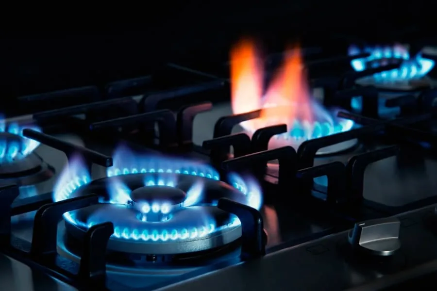 Cocina de gas con los fuegos encendidos y la llama visible