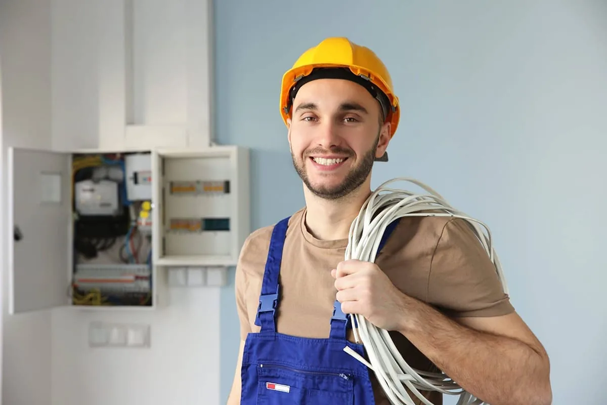 Electricista trabajando con herramientas sobre una instalación eléctrica interior