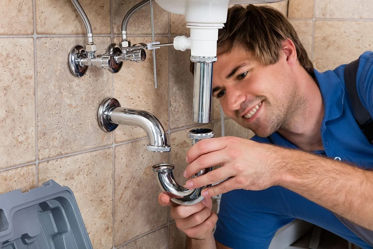 Fontanero reparando una tubería de agua en una instalación doméstica