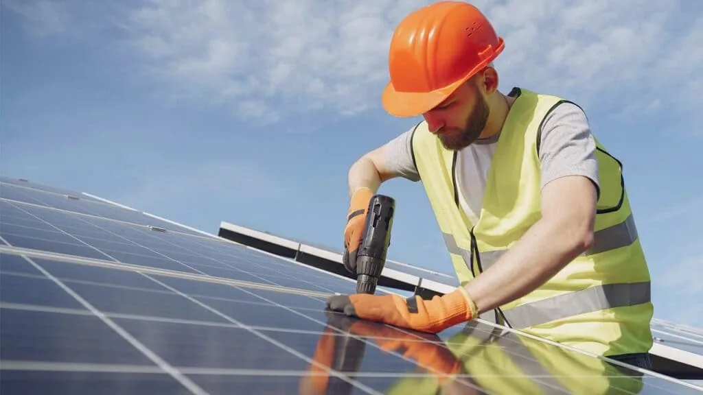 Vista de una cubierta con varias filas de paneles solares ya instalados y cableado recogido bajo los módulos