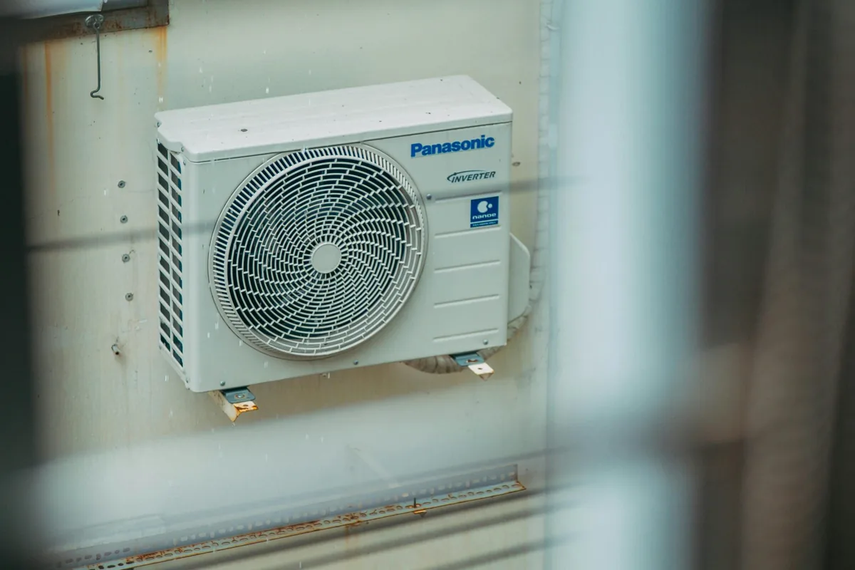 Instalador conectando las tuberías de refrigerante de un aire acondicionado