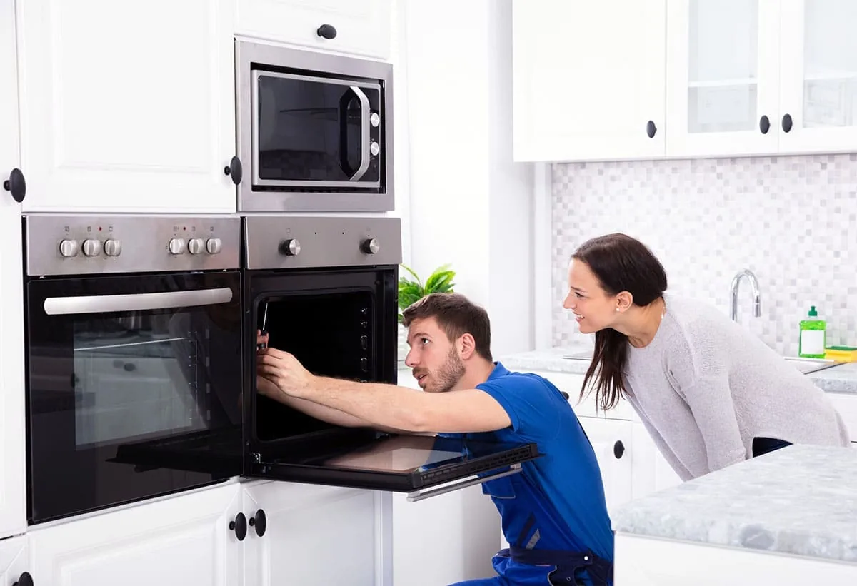 Técnico reparando un horno de cocina, servicio de reparación de hornos en Elche