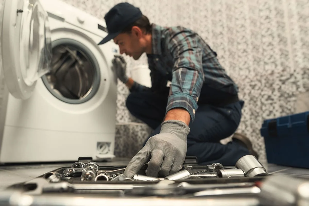 Técnico reparando una lavadora doméstica en una vivienda de Bilbao