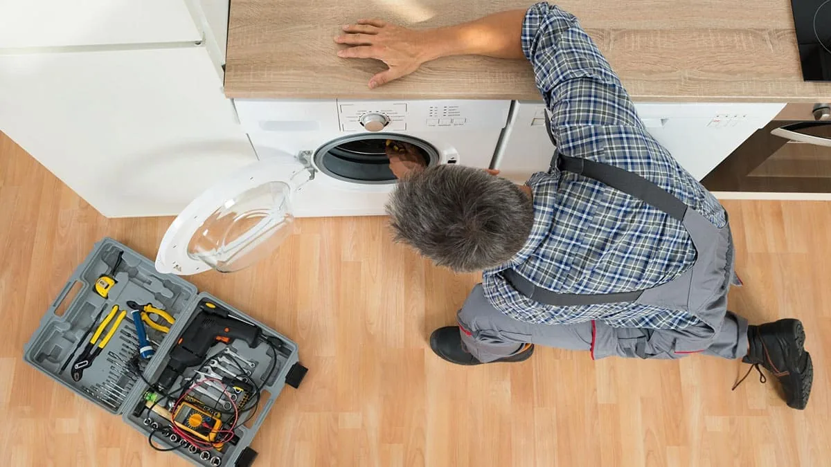 Técnico de servicio a domicilio reparando una lavadora en Bilbao