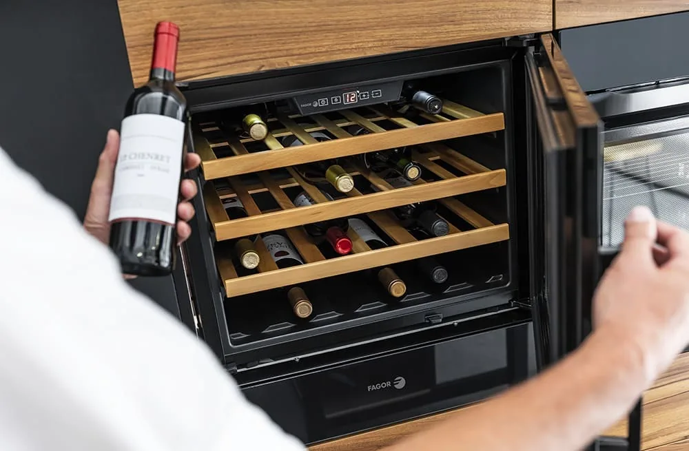 Vinoteca con botellas de vino y baldas de madera vista de cerca