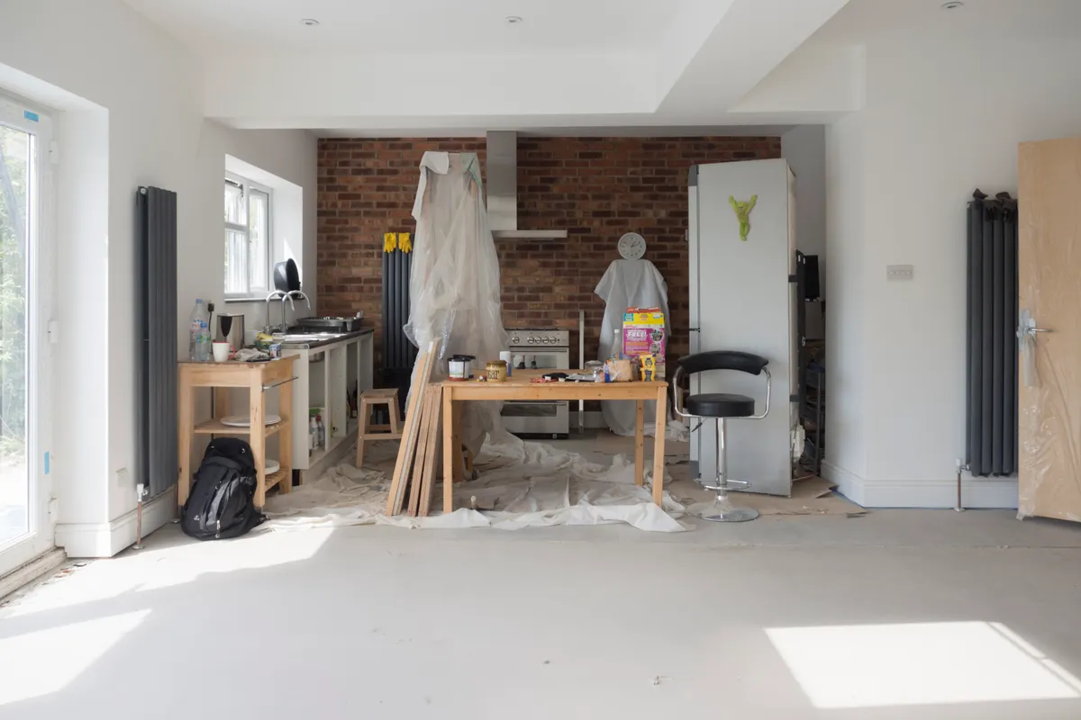 Ampliación luminosa de una cocina en obras con herramientas y materiales