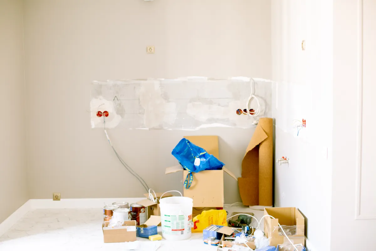 Habitación en obras con herramientas, material, cables y botes de pintura esparcidos